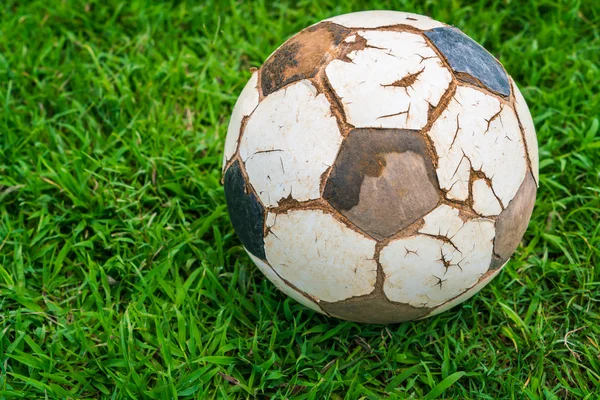 Old soccer ball on fresh spring green grass — Stock Photo, Image