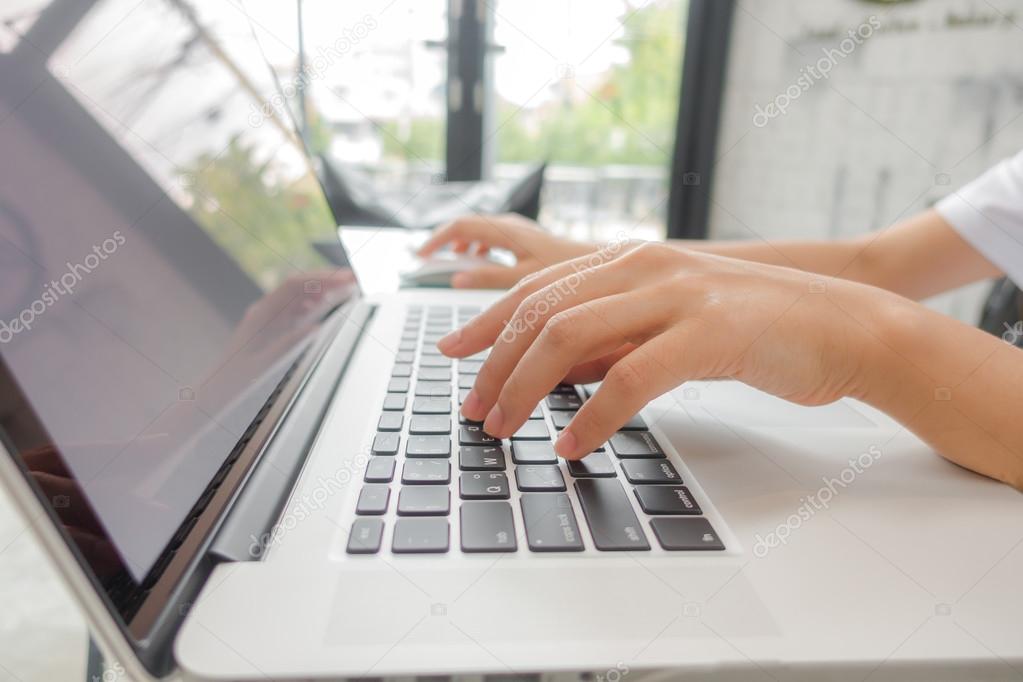 Closeup of business woman hand typing on laptop keyboard .