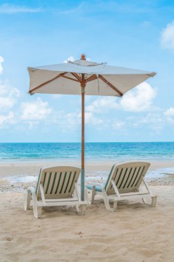 Güzel plaj sandalyeleri tropikal beyaz kum beac şemsiyesi ile