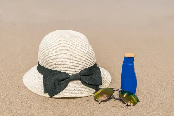 Sonnenbrille, Sonnencreme und Hut am weißen Sandstrand — Stockfoto