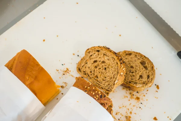 Rebanada de pan fresco y cuchillo de corte en la mesa en buffet  . — Foto de Stock