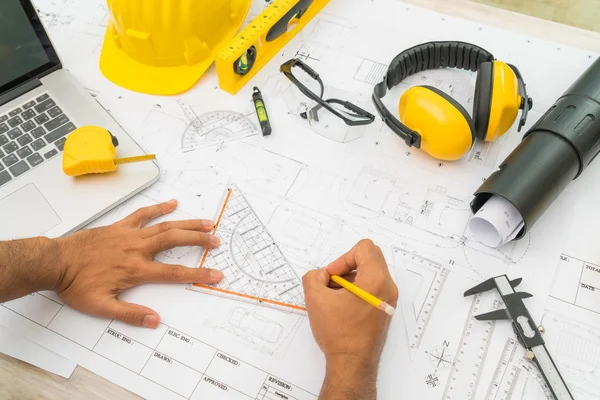 Entregar planos de construção com capacete amarelo e ferramenta de desenho — Fotografia de Stock