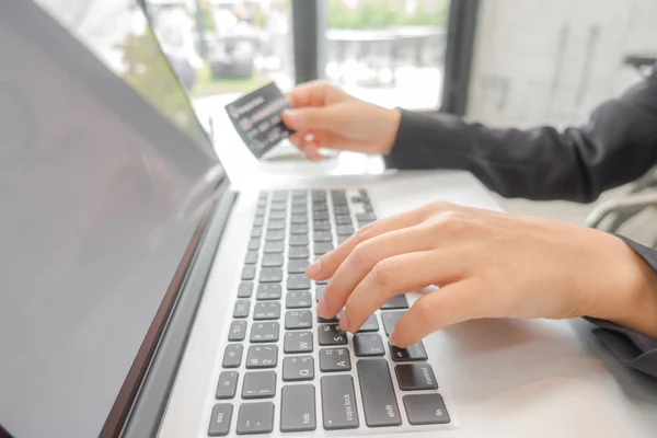 Руки, держащие кредитную карту и с помощью ноутбука для онлайн — стоковое фото