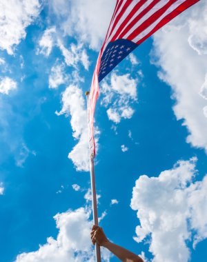 yıldızlar ve çizgiler ile Amerikan bayrağı eller blu karşı tutun