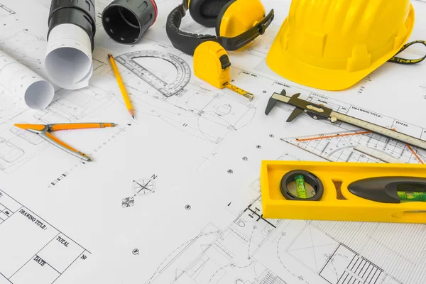 Planes de construcción con casco amarillo y herramientas de dibujo en bluep —  Fotos de Stock