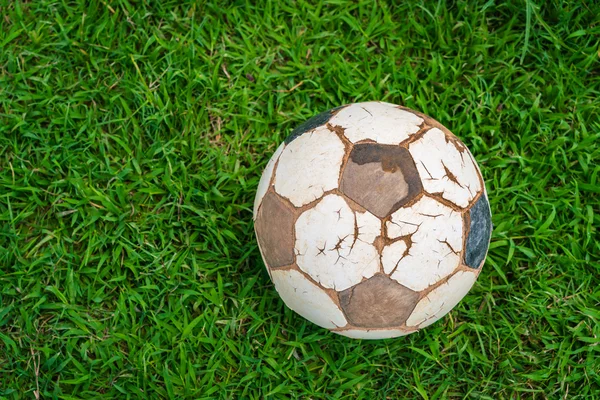 Old soccer ball on fresh spring green grass — Stock Photo, Image