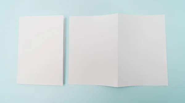 Papel modelo branco bifold sobre fundo azul  . — Fotografia de Stock