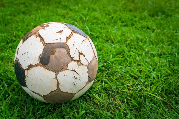 Old soccer ball on fresh spring green grass — Stock Photo, Image