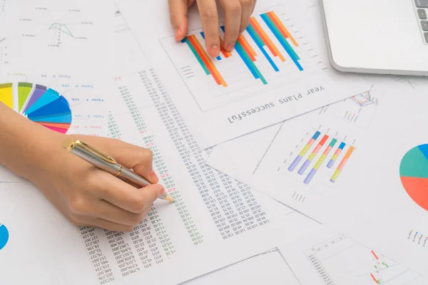 Zakelijke vrouw hand met financiële grafieken en laptop op de ta — Stockfoto