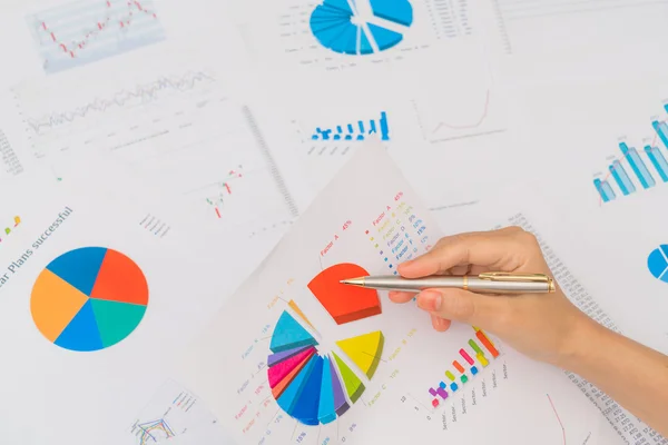 Zakelijke vrouw hand met financiële grafieken en laptop op de ta — Stockfoto