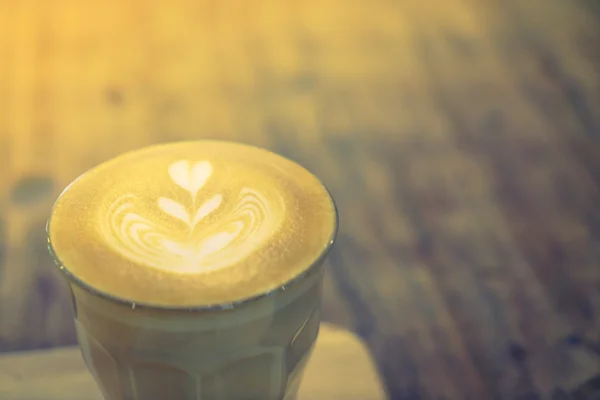 Hot latte art coffee on table ( Filtered image processed vintage