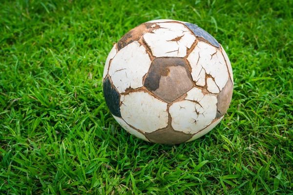 Old soccer ball on fresh spring green grass — Stock Photo, Image