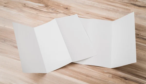 Driebladige wit sjabloon papier op hout textuur . — Stockfoto