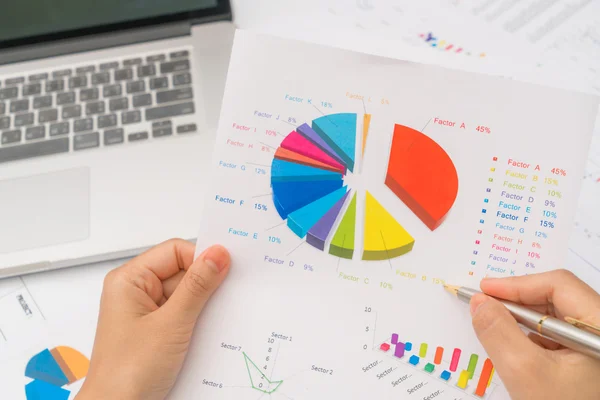 Üzleti nő kézzel pénzügyi diagramokat és a laptop a ta — Stock Fotó