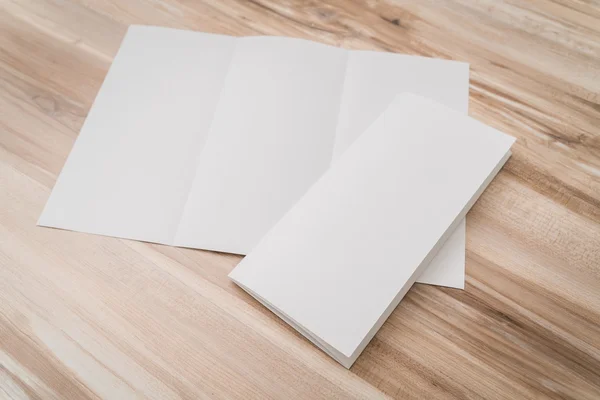 Trifold papel de plantilla blanco sobre textura de madera  . — Foto de Stock