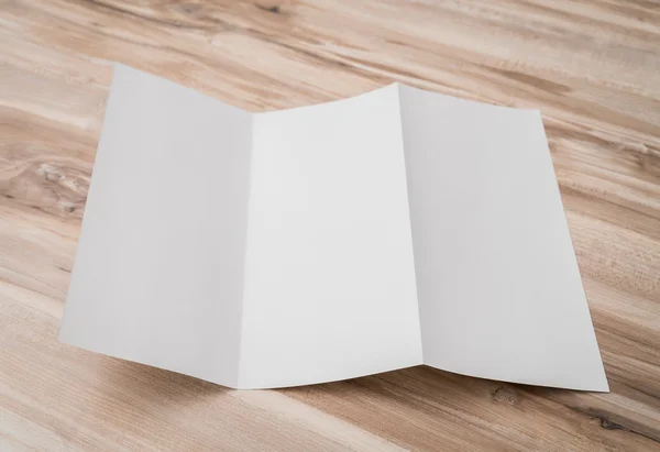 Dreifach weißes Schablonenpapier auf Holzstruktur . — Stockfoto