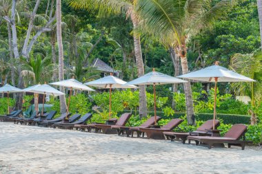 Güzel plaj sandalyeleri tropikal beyaz kum beac şemsiyesi ile