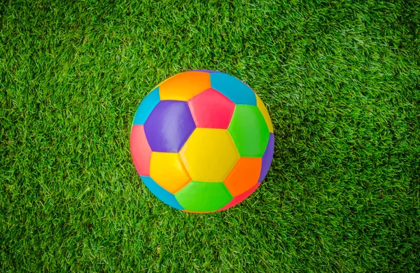 Gerçek deri renkli multi renk yeşil çimenlerin üzerinde futbol topu . — Stok fotoğraf