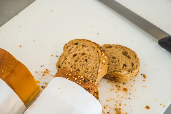Rebanada de pan fresco y cuchillo de corte en la mesa en buffet  . — Foto de Stock