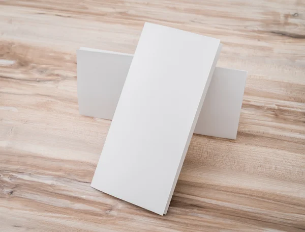 Trifold papel de plantilla blanco sobre textura de madera  . — Foto de Stock