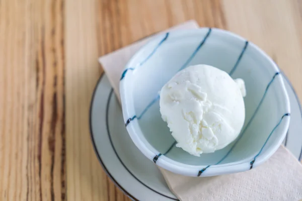 나무 탁자 위에 놓인 그릇에 담겨 있는 밀크 아이스크림 . — 스톡 사진