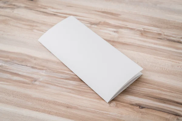 Trifold papel de plantilla blanco sobre textura de madera  . — Foto de Stock