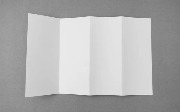 Τέσσερις - Διπλώστε το πρότυπο λευκό χαρτί σε γκρίζο φόντο . — Φωτογραφία Αρχείου