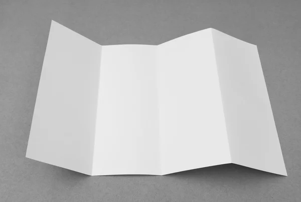 Vier - weißes Schablonenpapier auf grauem Hintergrund falten . — Stockfoto