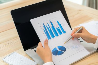 Kapalı toplantıda laptop ve mali grafikleri kullanarak iş adamları