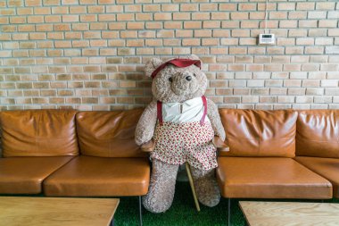 Sandalyede oturan sevimli ayıcık .