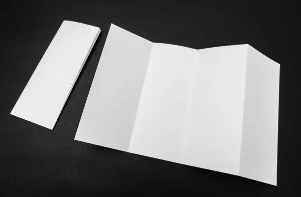 Quatro - papel modelo branco dobrável no fundo preto  . — Fotografia de Stock