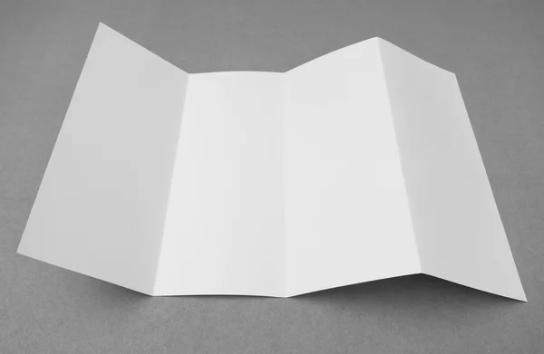 Négy - szeres papír fehér sablon, szürke háttér . — Stock Fotó