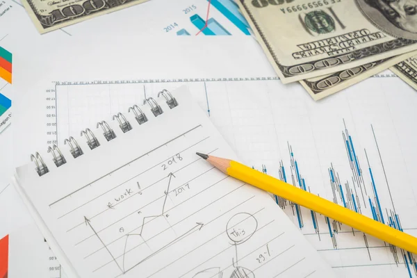 Financial charts on the table with dollars banknotes . — Stock Photo, Image