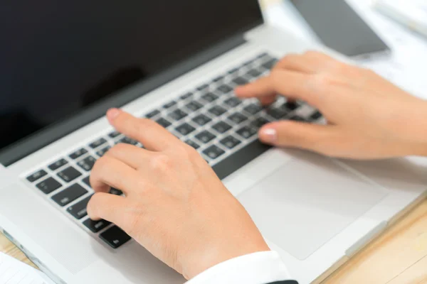Primer plano de la mujer de negocios escribiendo a mano en el teclado del ordenador portátil . —  Fotos de Stock