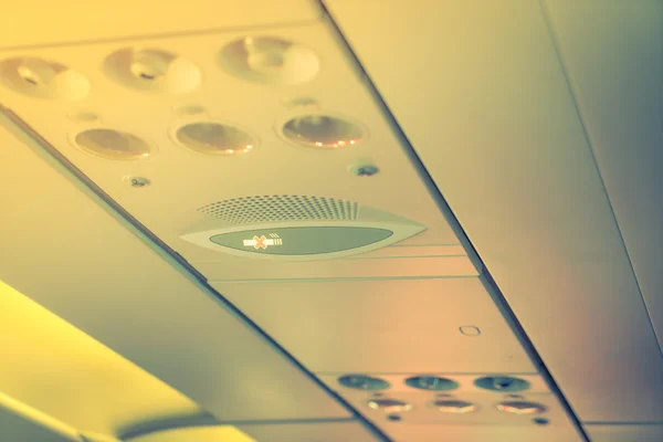 No smoking sign and seat belt sign on the airplane .  ( Filtered — Stock Photo, Image