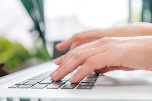 Primo piano della mano della donna d'affari che digita sulla tastiera del computer portatile . — Foto Stock