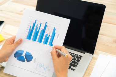 Kapalı toplantıda laptop ve mali grafikleri kullanarak iş adamları