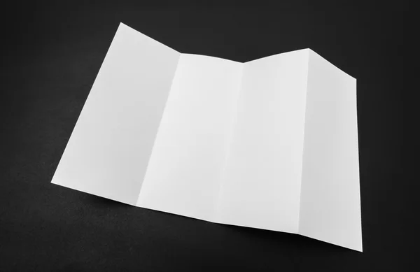 Vier - vouwen wit sjabloon papier op zwarte achtergrond . — Stockfoto