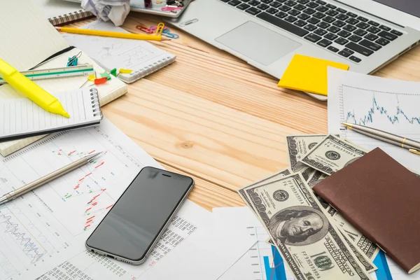 Financial charts on the table with laptop , phone ,dollars bankn — Stock Photo, Image