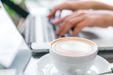 Closeup Latte Kahve sanat ve kadın el laptop keya yazma