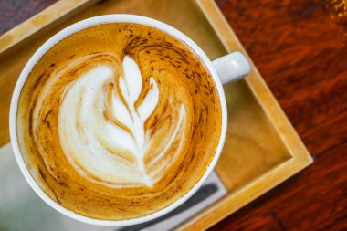 Ahşap masadaki Latte Kahve Sanatı .