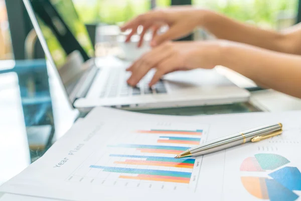 Mão de mulher de negócios com gráficos financeiros e laptop na mesa — Fotografia de Stock