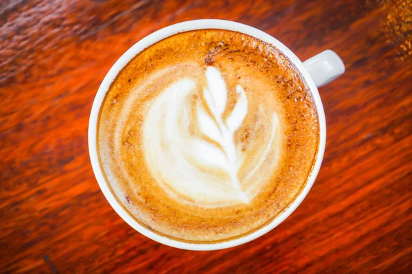 Kawa Latte sztuki na drewnianym stole . — Zdjęcie stockowe