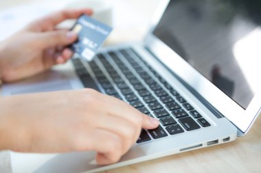 kredi kartı tutan ve dizüstü bilgisayar kullanarak çevrimiçi eller