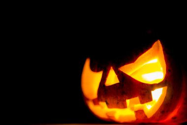 siyah arka plan üzerinde Halloween korkunç yüzünü kabak