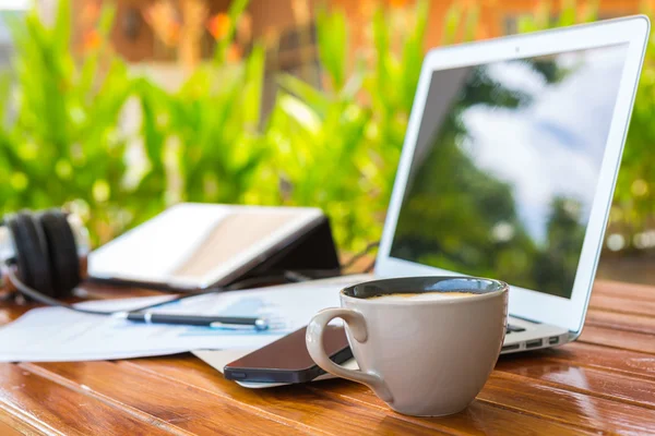 Laptop, tablet, smartphone e xícara de café com documentação financeira — Fotografia de Stock