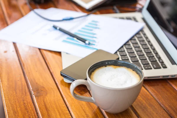 Portátil, tableta, teléfono inteligente y taza de café con documentación financiera —  Fotos de Stock