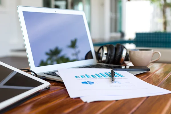 Laptop, tablet , smartphone and coffee cup with financial docume — Stock Photo, Image