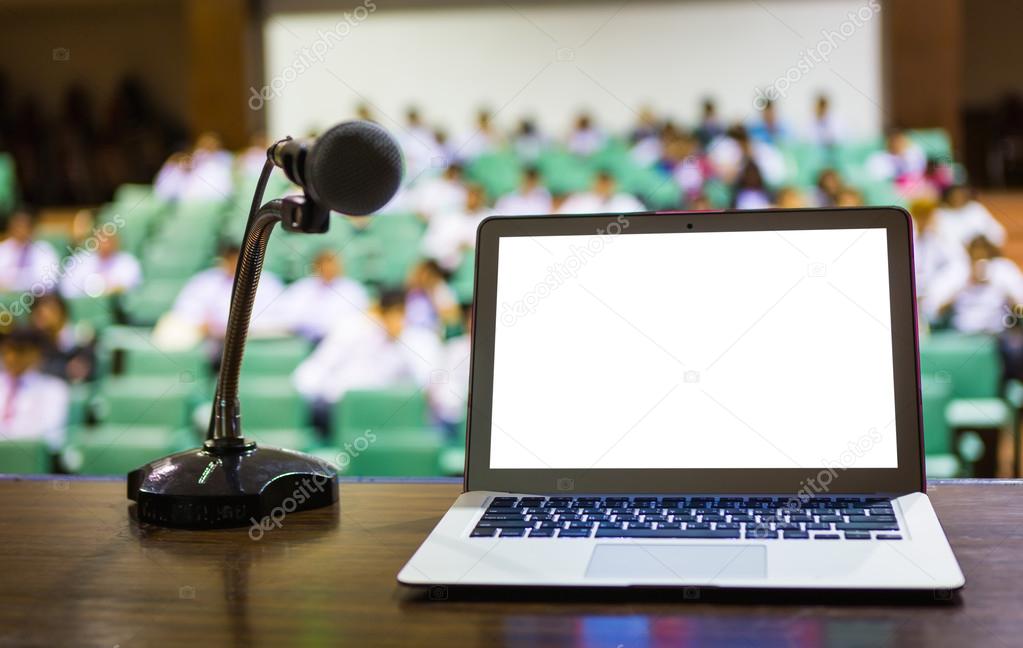 Laptop and microphone on the rostrum in empty conference hall
