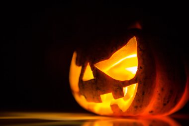 siyah arka plan üzerinde Halloween korkunç yüzünü kabak
